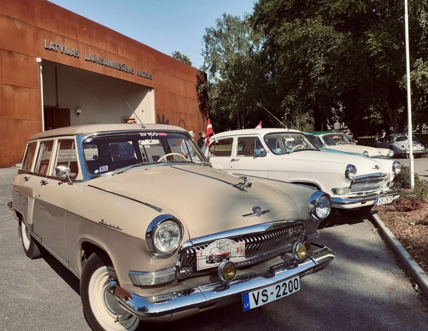 Dažādi retro auto pie muzeja fasādes