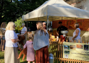 Krāsaini svētku dalībnieki pie Latvijas Lauksaimniecības muzeja ekspresizstādes “Sieru ēdu, pienu dzēru, sūkalās(i) mazgājos” stenda