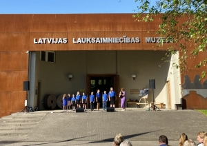 Muzeja galvenā ieeja, pie kuras uzstājas skolēni zilos kreklos