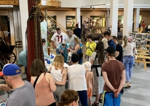 Muzeja telpās notiek eksperiments, pie kura pulcējušies daudz interesentu