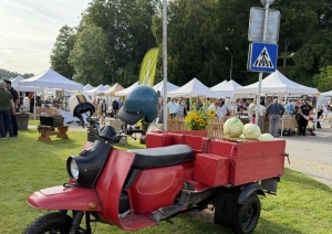 Sarkans kravas motorollers “Muravej” ar kāpostiem pie ieejas Dižmāras gadatirgū Talsos