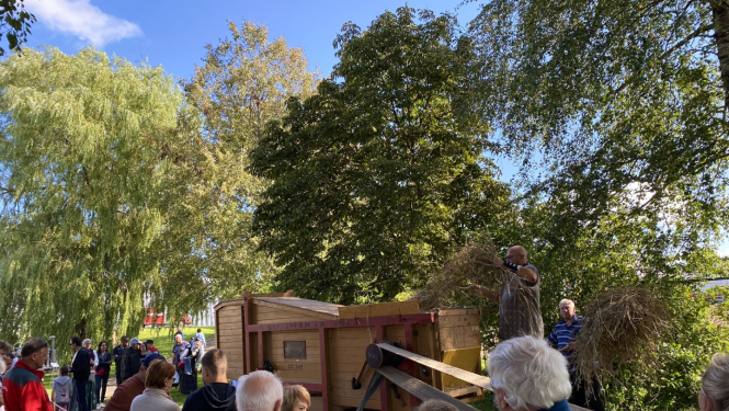 Pasākuma apmeklētāji vēro labības kuļmašīnu “Imanta” darbībā