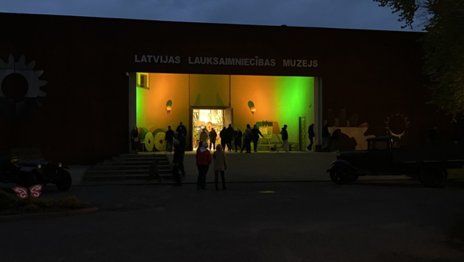 Apmeklētāju plūsma pie izgaismotas muzeja ieejas Muzeju nakts pasākuma laikā