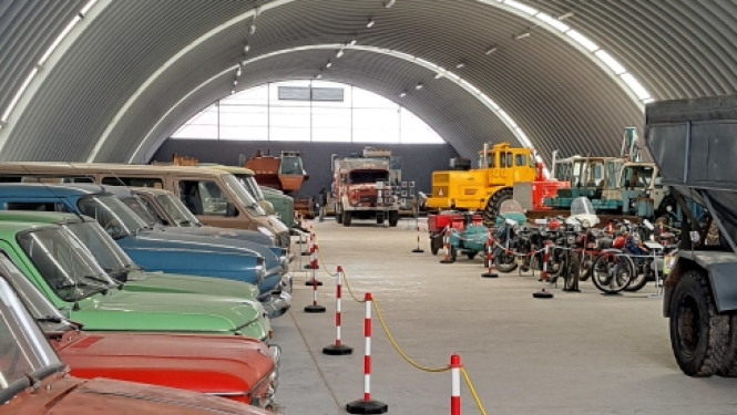 Latvijas Lauksaimniecības muzeja izstāžu zāle ar seniem, krāsainiem transportlīdzekļiem