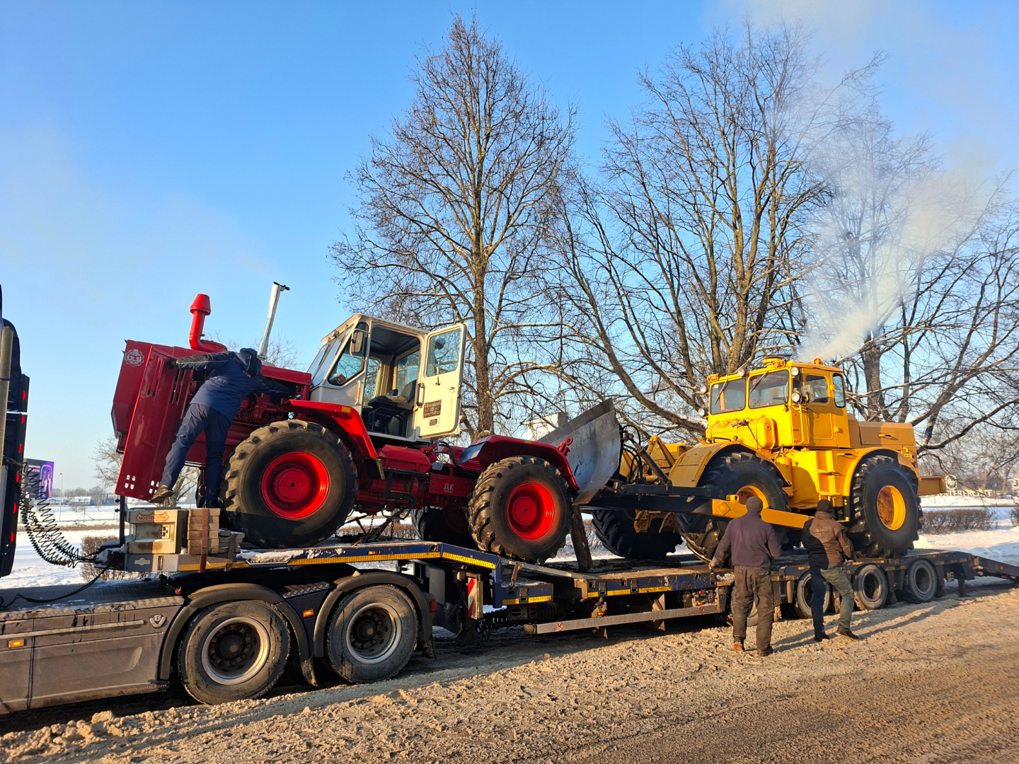 Divu senlaicīgu, krāsainu traktoru nobraukšana no treilera