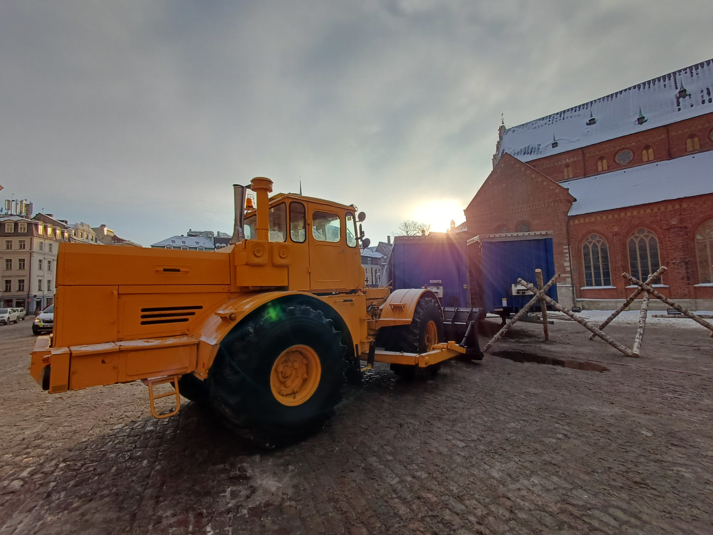 Dzeltens, senlaicīgs traktors sniegotā Doma laukumā