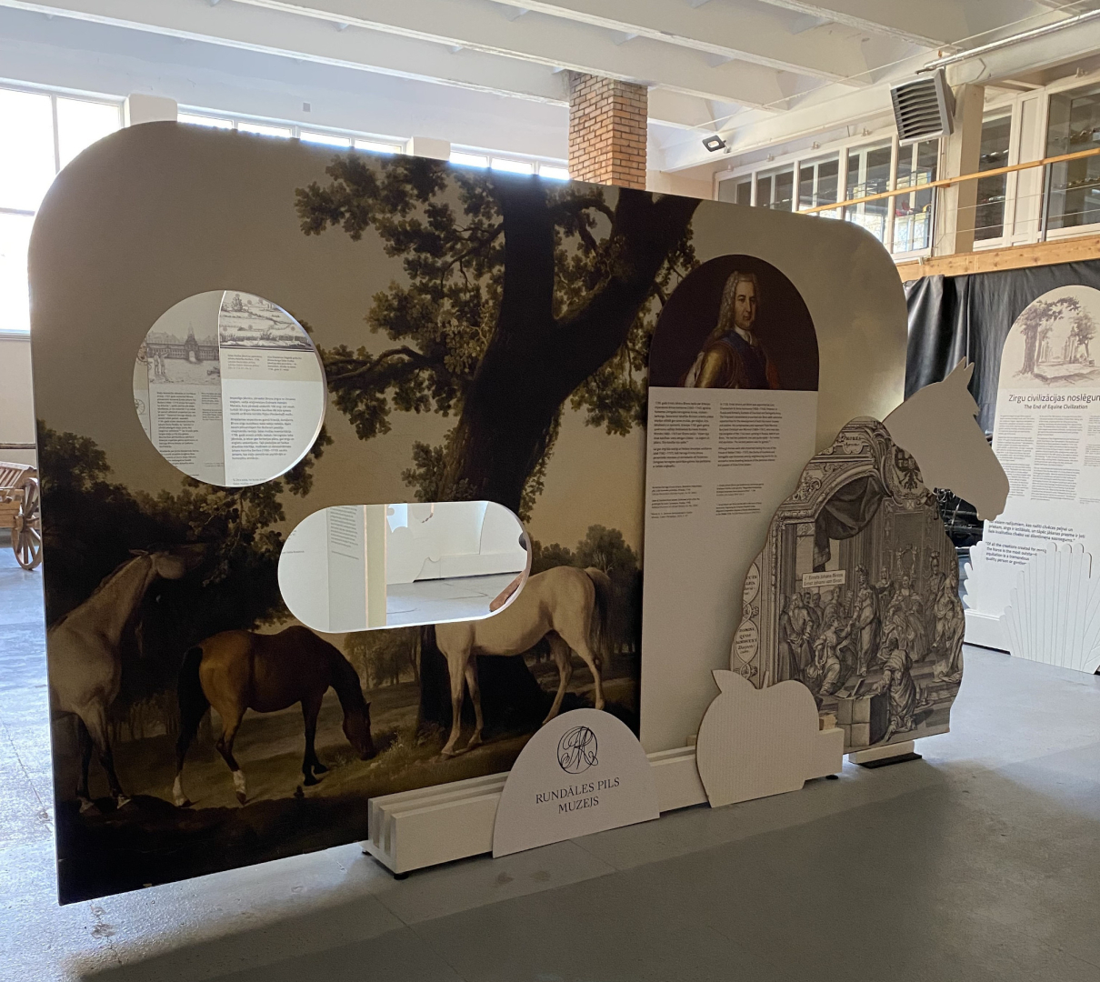 Liels, informatīvs stends muzeja telpās par zirgu un zirgošanās tēmu