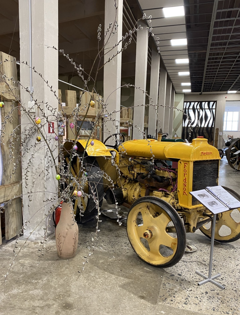 Dzeltens traktors Lieldienu kompozīcijā Latvijas Lauksaimniecības muzeja telpās