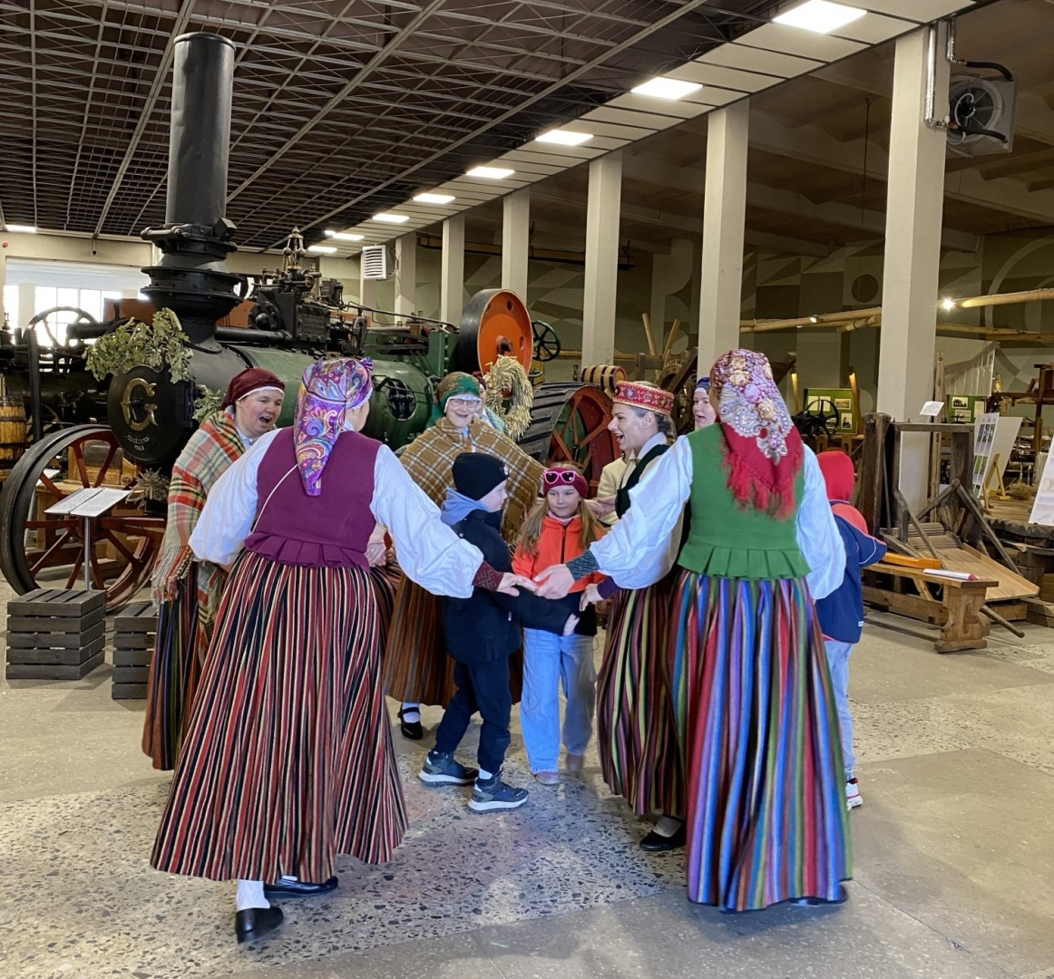 Folkloras kopa muzicē un iet rotaļās kopā ar apmeklētājiem Latvijas Lauksaimniecības muzeja telpās