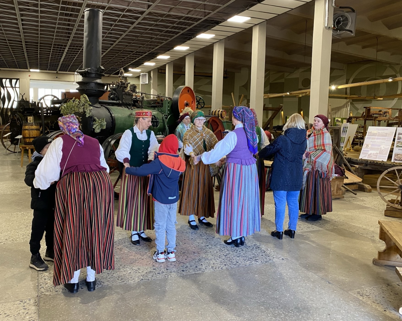 Folkloras kopa muzicē un iet rotaļās kopā ar apmeklētājiem Latvijas Lauksaimniecības muzeja telpās