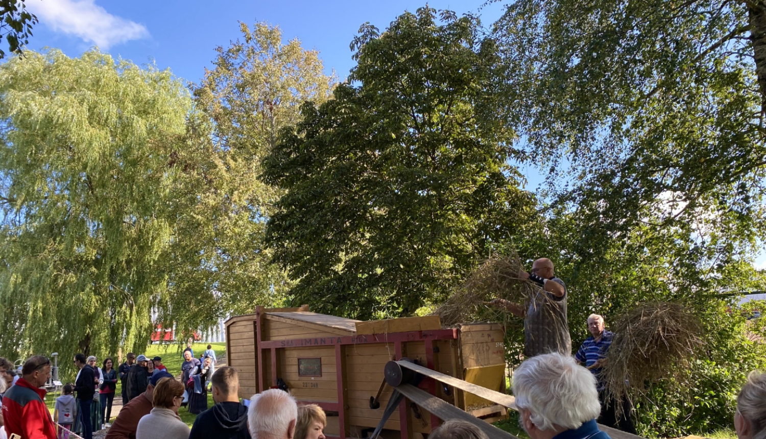 Pasākuma apmeklētāji vēro labības kuļmašīnu “Imanta” darbībā