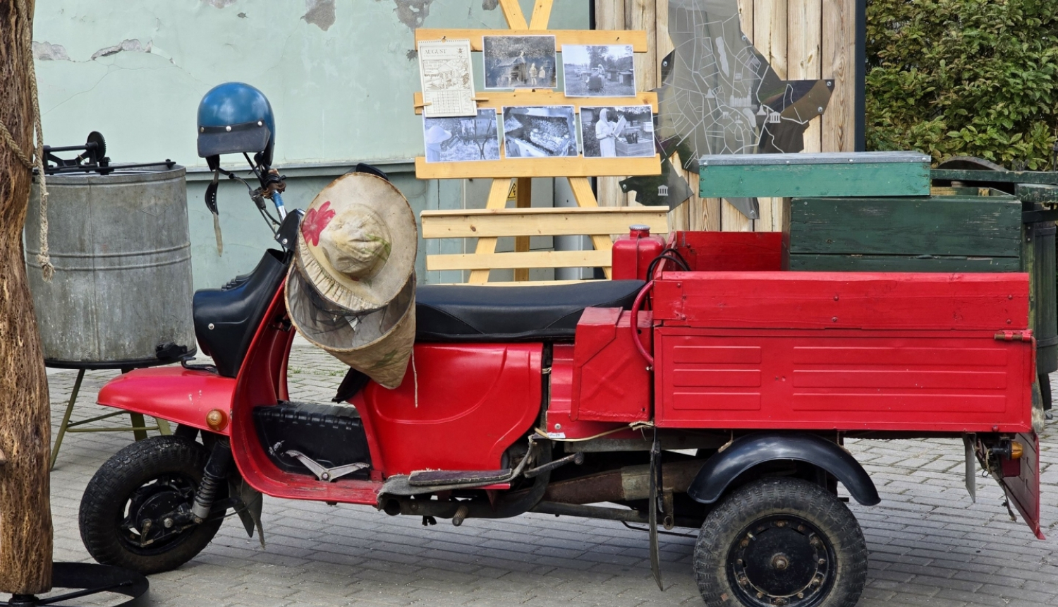 Sarkans motorollers ar kravas kasti pilsētvidē